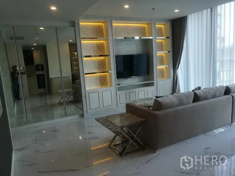 公寓 出租在Pathum Wan, Bangkok - 明亮客厅，带大理石定制壁柜、电视墙、转角沙发与落地纱帘