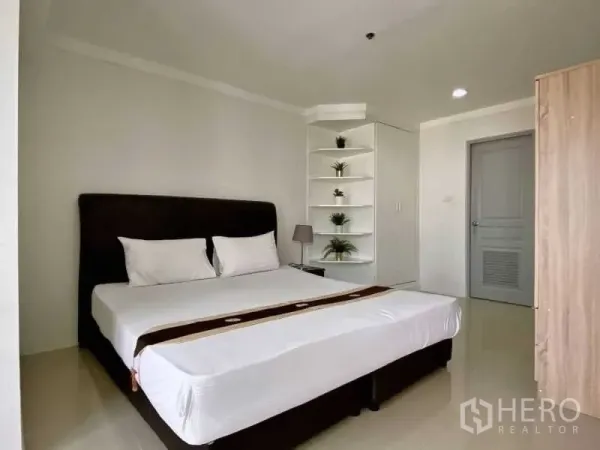公寓 出租在Khlong Toei, Bangkok - 主卧配大床、内置搁架与衣柜，色调素雅。