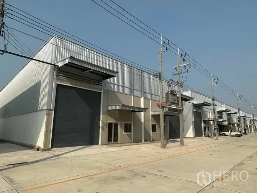 工厂 出租在Bang Phli, Samut Prakan - 现代工厂排屋，金属外墙，大型卷帘门与宽阔混凝土车道