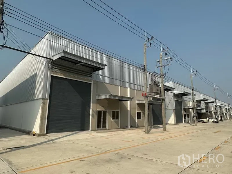 工厂 出租在Bang Phli, Samut Prakan - 现代工厂排屋，金属外墙，大型卷帘门与宽阔混凝土车道