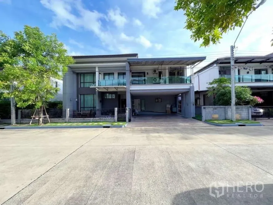 独立式住宅 出售在Prawet, Bangkok - 现代两层独栋外观，设阳台、宽车棚与前院栅栏门。