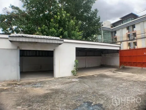 คลังสินค้า ให้เช่าในLak Si, Bangkok - โรงเรือน/ที่จอดรถมีหลังคา ช่องเปิดหลายช่อง กับประตูรั้วสีแดง