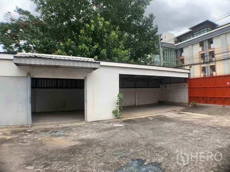 คลังสินค้า ให้เช่าในLak Si, Bangkok - โรงเรือน/ที่จอดรถมีหลังคา ช่องเปิดหลายช่อง กับประตูรั้วสีแดง