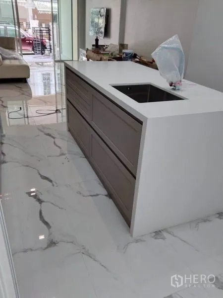 Townhouse for rent in Yan Nawa, Bangkok - Modern kitchen island with sink and storage facing the living room.