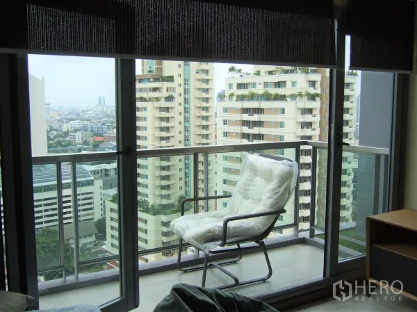 คอนโด ให้เช่าหรือขายในWatthana, Bangkok - ระเบียงส่วนตัวราวกระจก มีเก้าอี้พักผ่อนและวิวเมืองตึกสูง
