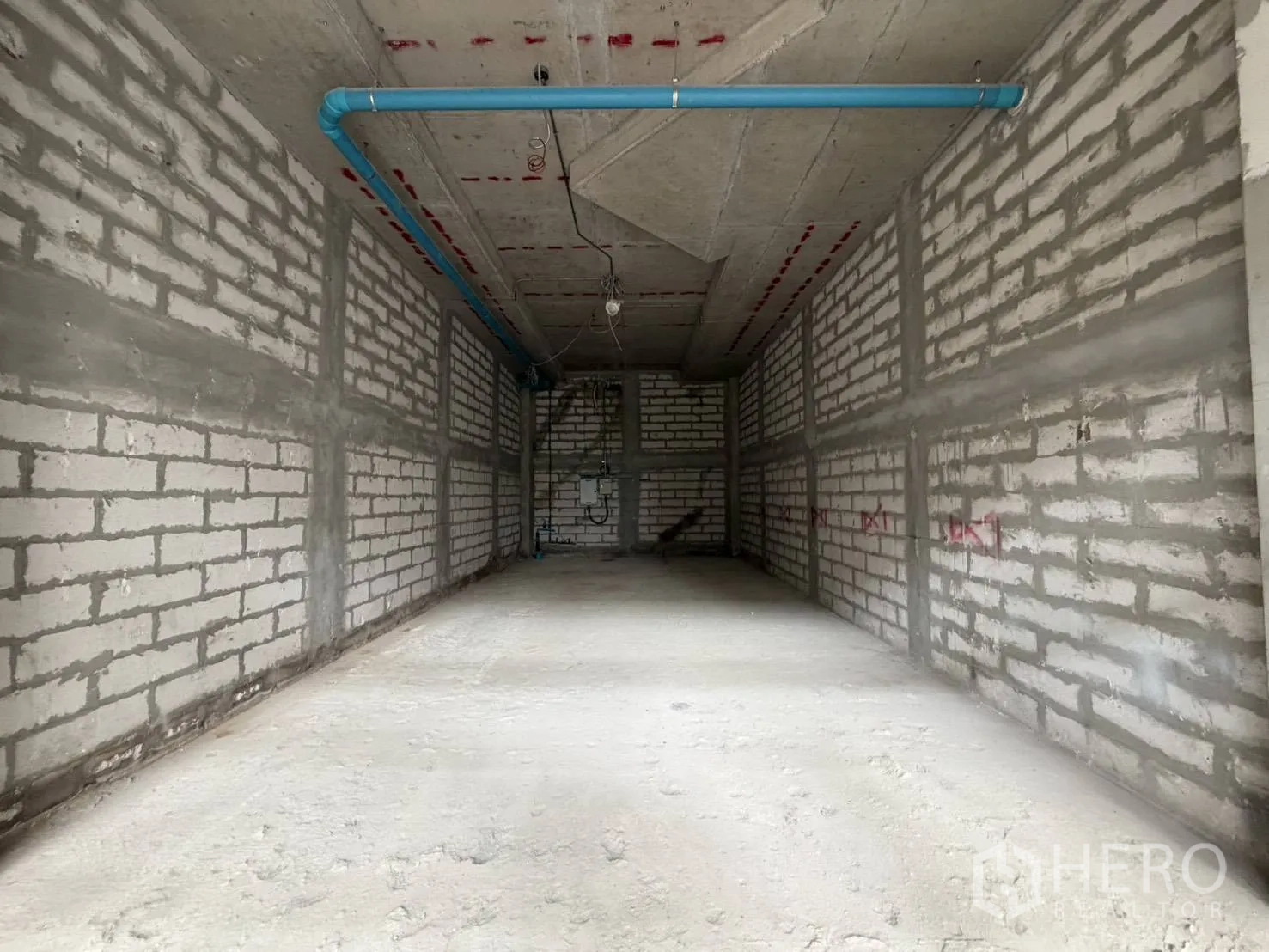 พื้นที่ขายของ for rent in Khlong Toei, Bangkok - ภายในรูปทรงสี่เหลี่ยมผืนผ้ายาว เปิดโล่ง พร้อมจุดสาธารณูปโภคและท่อน้ำสีฟ้า.