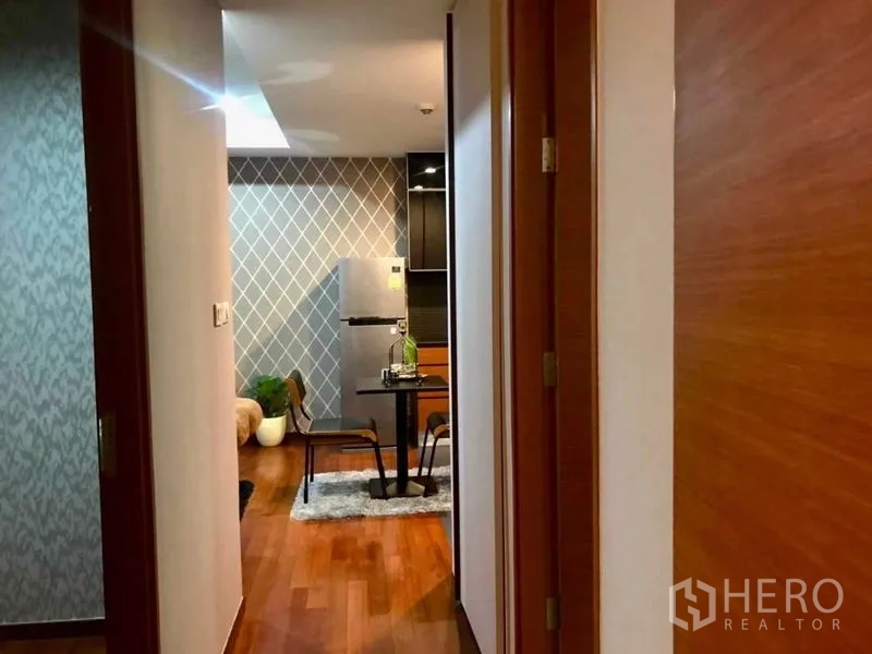 公寓 出租在Watthana, Bangkok - 走廊望向厨房与餐区，带菱格纹特色墙。