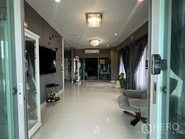 独立式住宅 出租或出售在Lat Krabang, Bangkok - 从入口望向明亮客厅，白色瓷砖地面与落地窗帘