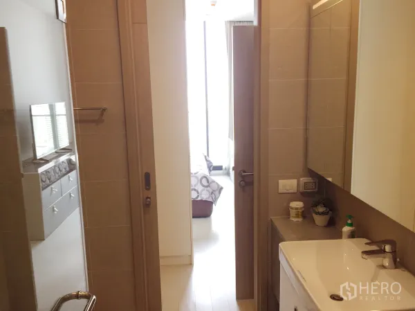คอนโด ให้เช่าในPathum Wan, Bangkok - ห้องน้ำสมัยใหม่พร้อมอ่างล้างหน้าและประตูบานเลื่อนเปิดสู่ห้องนอนสว่าง
