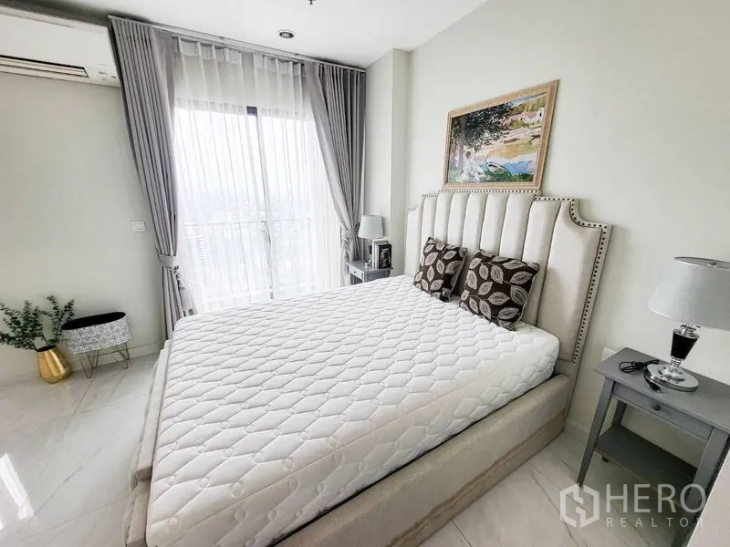 公寓 出售在Watthana, Bangkok - 卧室配高靠背软包床、床头柜和通阳台的玻璃门