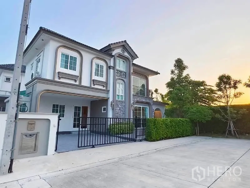บ้านเดี่ยว for rent in Bang Phli, Samut Prakan - บ้านเดี่ยวสองชั้นสไตล์คลาสสิกพร้อมระเบียง ประตูรั้ว และทางเข้ารถกว้าง.