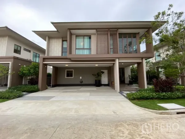Detached House for sale in Bang Kapi, Bangkok - Modern two-storey detached house facade with covered two-car carport, landscaped garden and large windows in Bang Kapi.