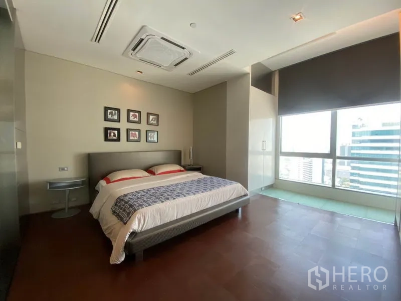 Condominium for rent in Sathon, Bangkok - Spacious second bedroom with king bed, city-view window, wardrobe and ceiling cassette air-conditioner.