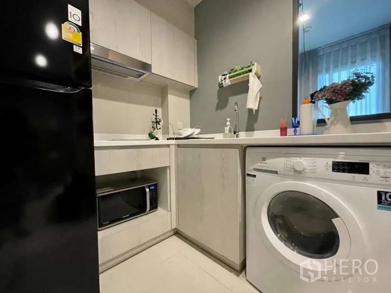 Condominium for rent in Pathum Wan, Bangkok - L-shaped kitchenette with sink, microwave and front-load washing machine