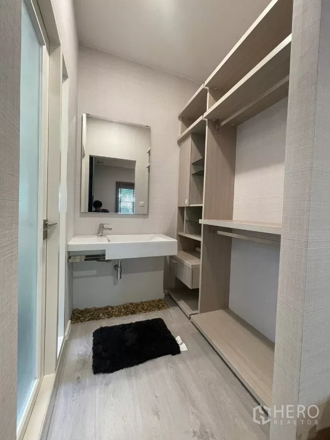 Detached House for rent in Prawet, Bangkok - Walk-in closet with built-in shelving and vanity sink.