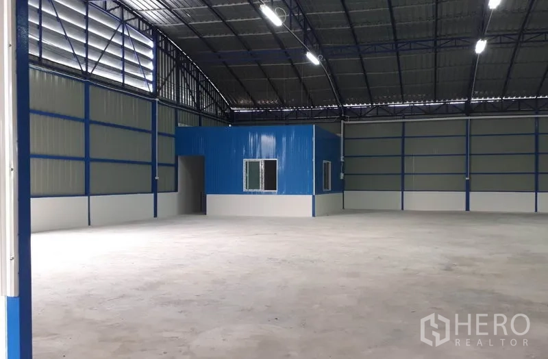 货栈 出租在Nong Chok, Bangkok - 仓库内部带蓝色办公室隔间，开阔储存空间与高挑屋顶
