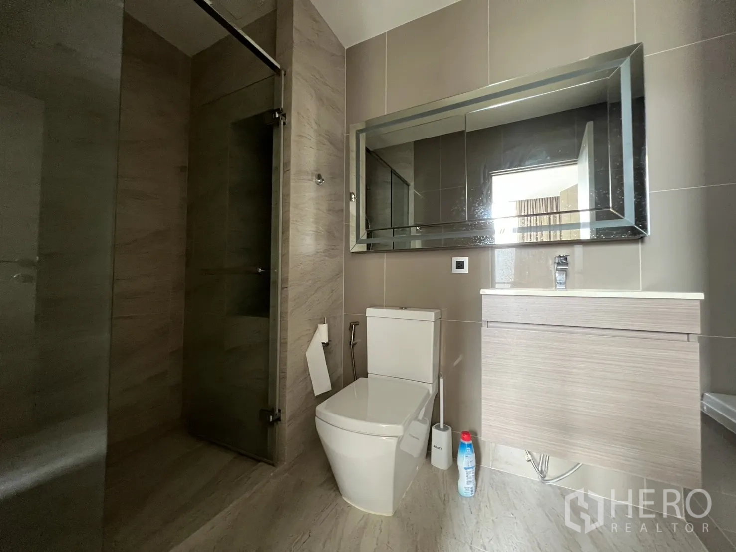 คอนโด for rent in Watthana, Bangkok - ห้องน้ำสมัยใหม่มีตู้อาบน้ำกระจก อ่างล้างหน้าแบบแขวน และโถสุขภัณฑ์.