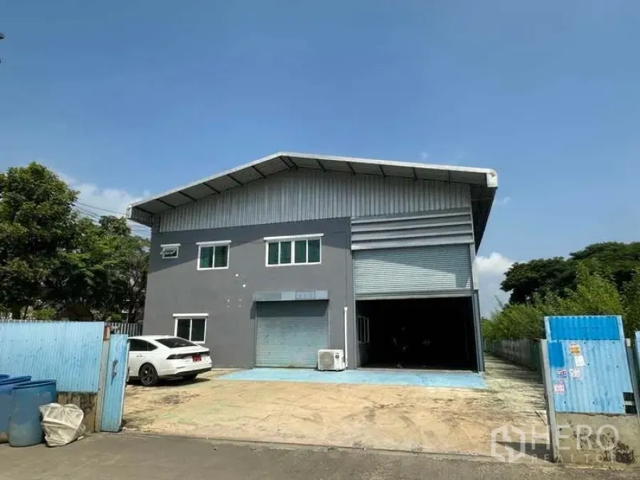 Warehouse for rent in Pathum Thani - Street-facing exterior of the warehouse with gated entrance and parking bay.
