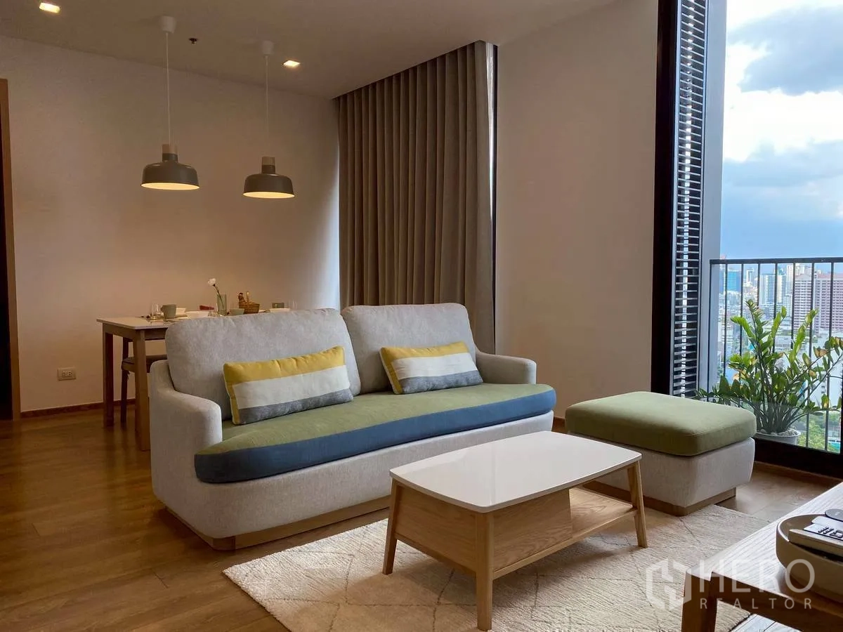 คอนโด for rent in Watthana, Bangkok - โซนนั่งเล่นมีโซฟา ออตโตมัน โต๊ะกลาง และต้นไม้ริมระเบียง