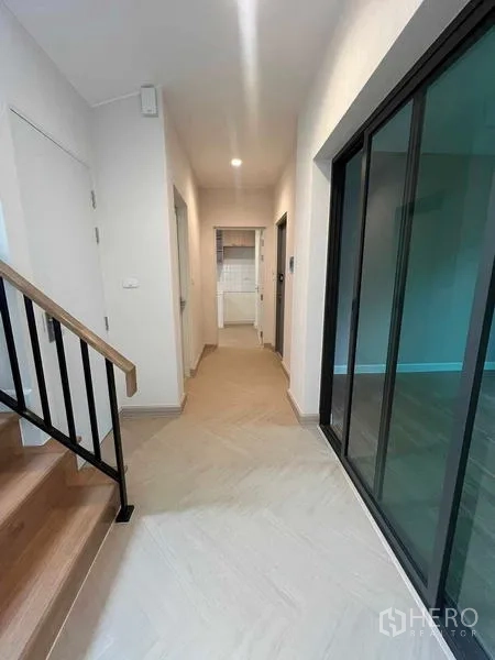 Detached House for sale in Bang Kruai, Nonthaburi - Ground-floor hallway with glass partition, stairway and access to the kitchen and bathroom.