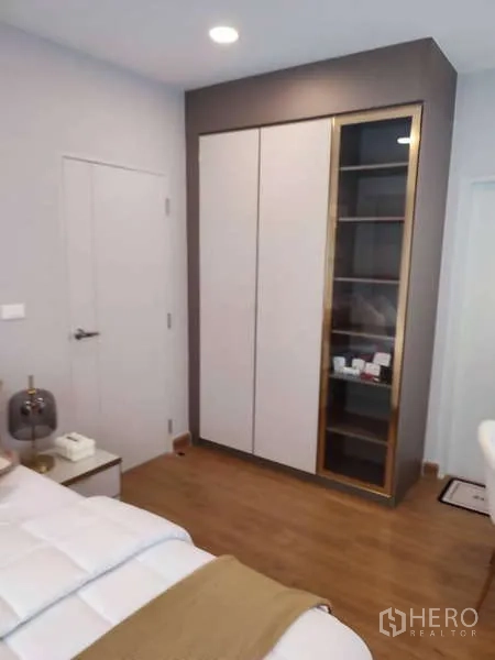 Detached House for rent in Bang Phli, Samut Prakan - Bedroom corner featuring a built-in wardrobe and wood flooring beside a white door.