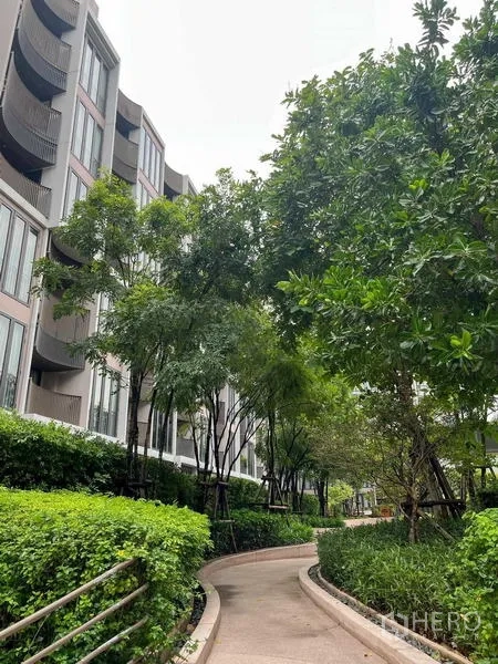 公寓 出售在Watthana, Bangkok - 两栋低层公寓之间的林荫花园步道。