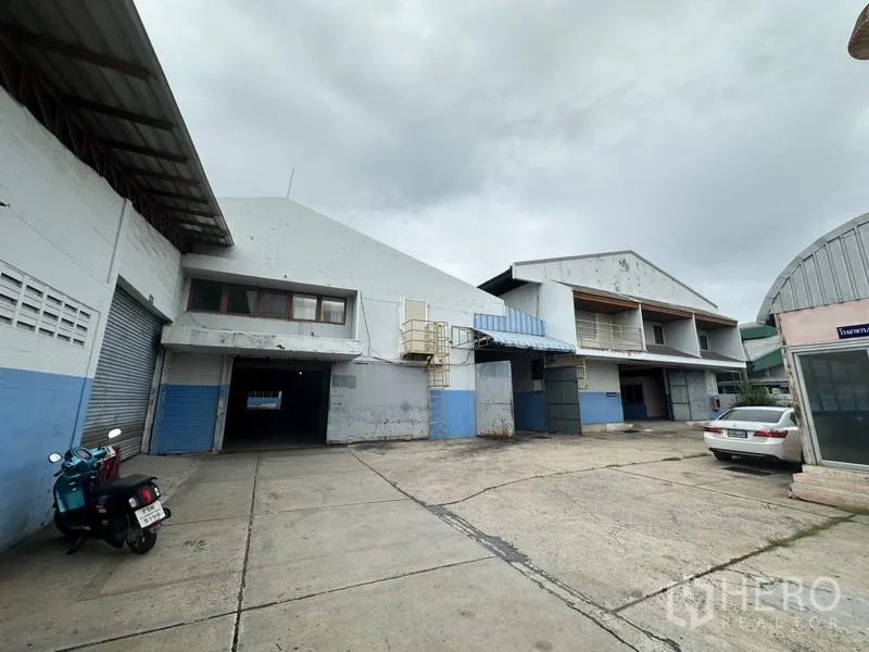工厂 出售在Khlong Luang, Pathum Thani - 入口前院，带装卸月台、卷帘门和停车位。
