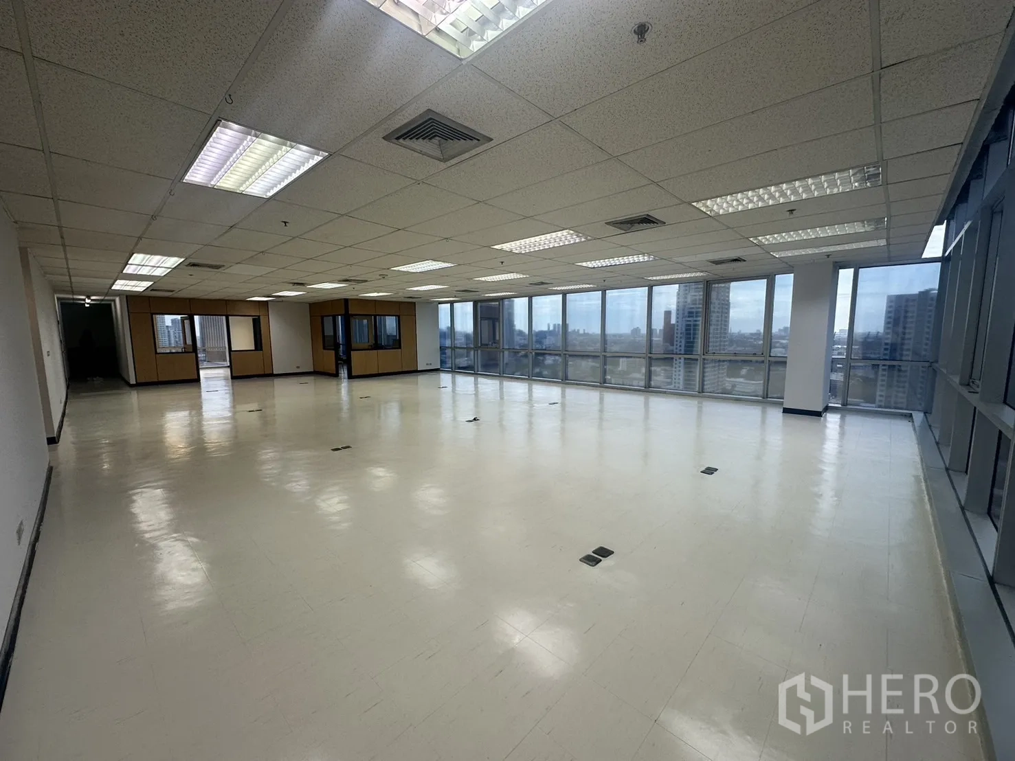 Office Space for rent - Corner office featuring glass curtain walls on two sides, glossy floor, and panoramic Bangkok city views.