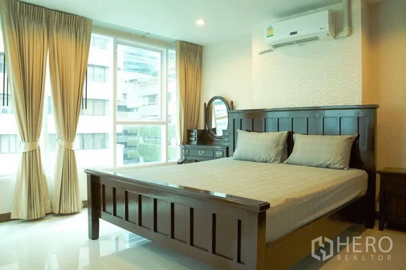 公寓 出售在Watthana, Bangkok - 卧室配深色木床、梳妆台、米色窗帘与大窗户。