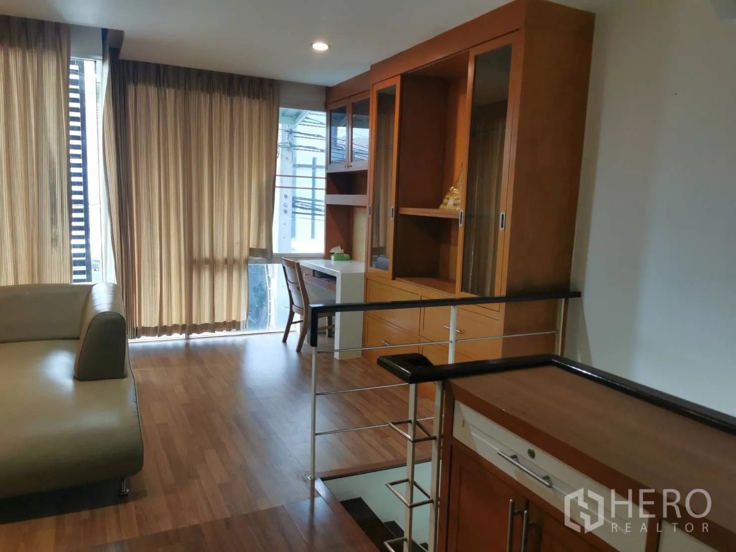 Townhouse for rent or sale in Yan Nawa, Bangkok - Upper floor landing with floor-to-ceiling windows, sofa seating and extensive built-in storage.