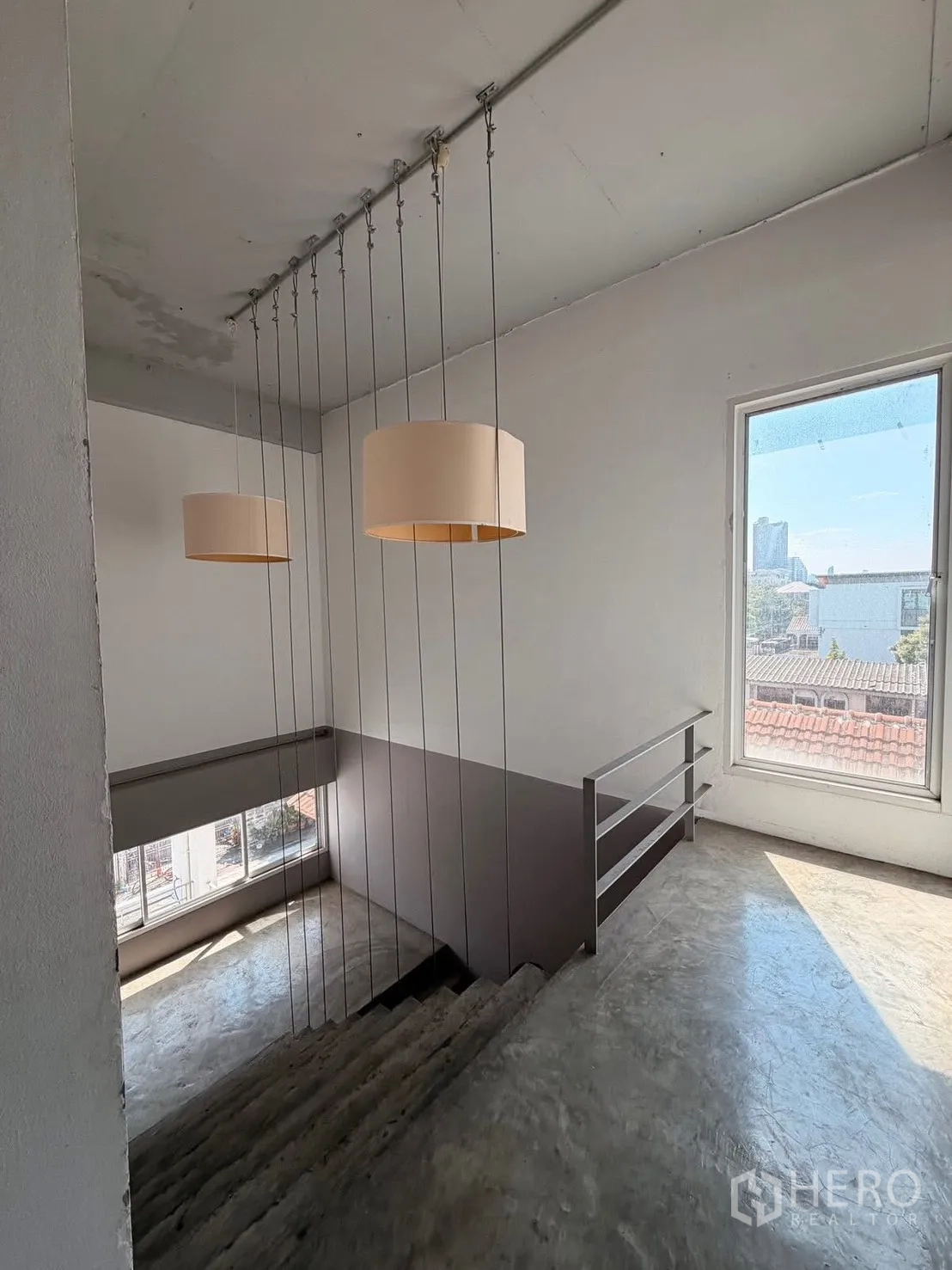 带办公室的家 for rent in Huai Khwang, Bangkok - 楼梯平台设大窗与吊灯，可眺望城市景观。