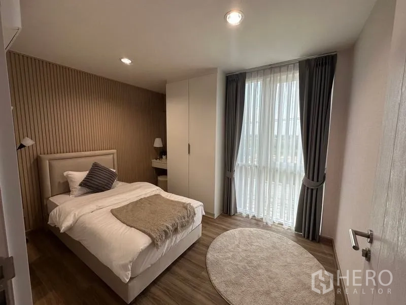 Warehouse for sale in Pathum Thani - Cozy bedroom with tall window, curtains and built-in wardrobe in the office residence.