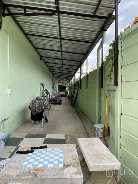 Warehouse for rent in Khan Na Yao, Bangkok - Covered side aisle used for storage and utilities behind the warehouse.