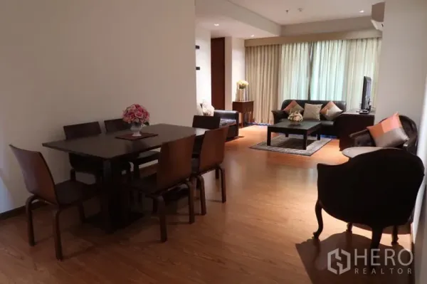 Condominium for rent in Khlong Toei, Bangkok - Open-plan dining and living area with six-seat table, sofa set and full-length curtains.