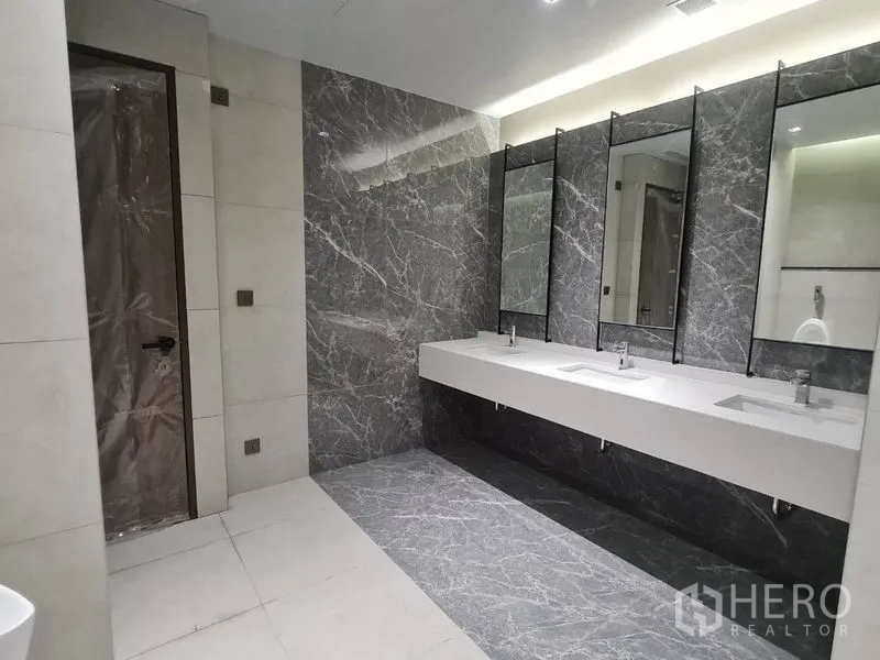 สำนักงาน ให้เช่า - ห้องน้ำกว้างขวาง ผนังไฮไลต์หินอ่อน เคาน์เตอร์ยาว พร้อมกระจกและอ่างล้างมือหลายจุด