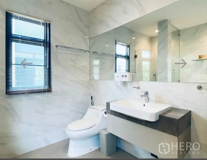 Detached House for sale in Saphan Sung, Bangkok - Bright bathroom with long mirror, vanity and toilet.