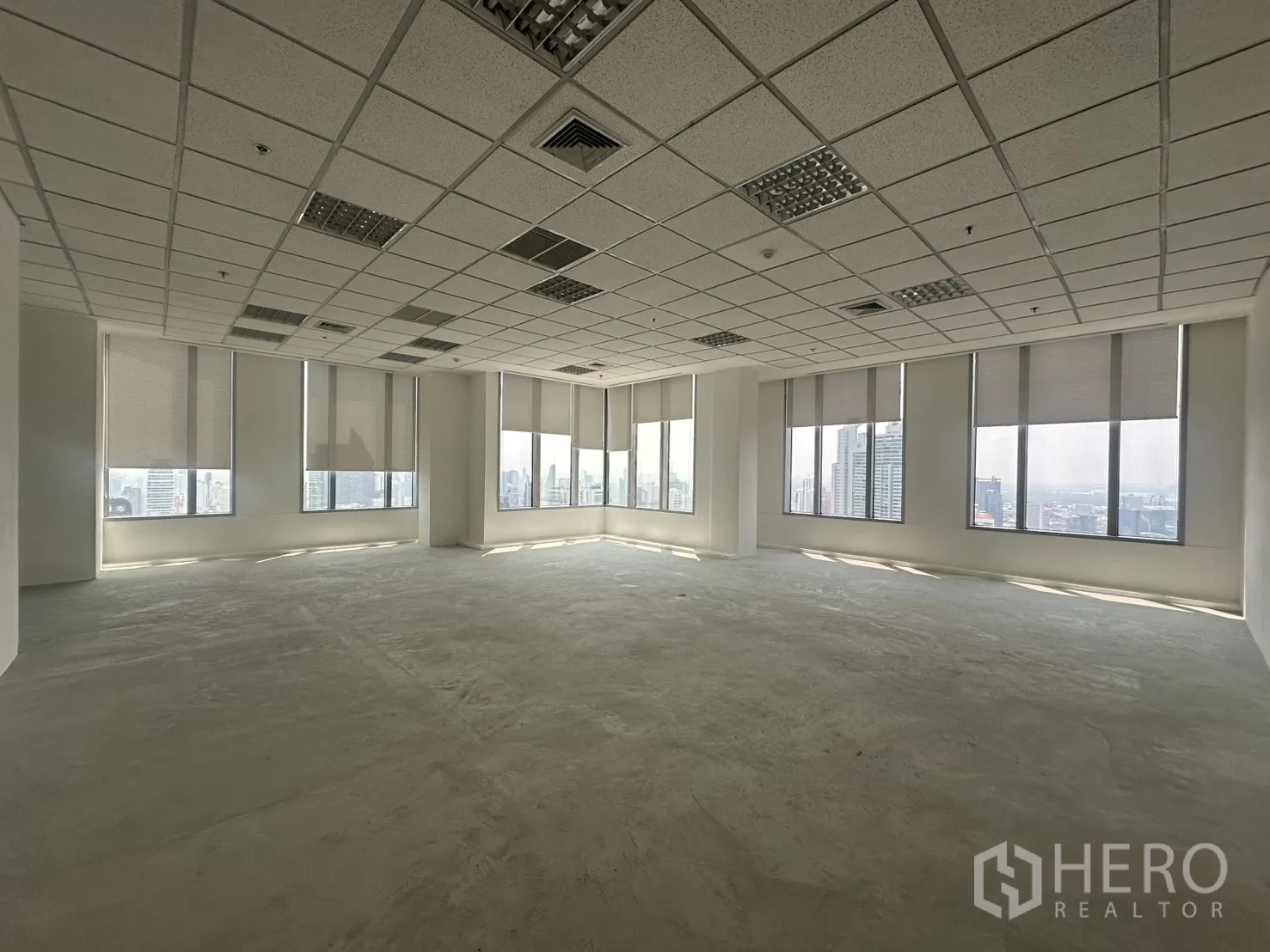 Office Space for rent in Khlong Toei, Bangkok - Corner office area with wraparound windows, roller blinds, and panoramic skyline outlook.