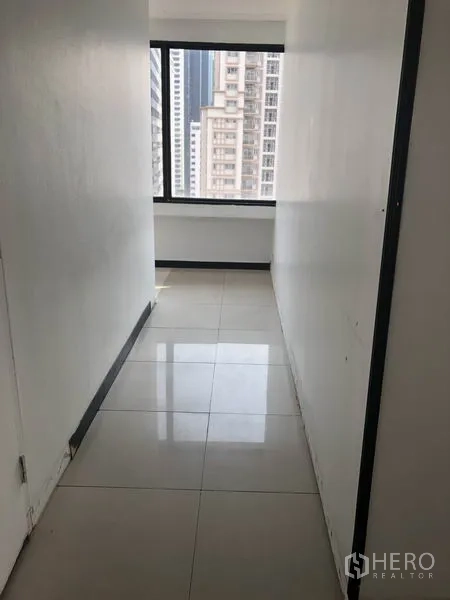 办公空间 出租在Watthana, Bangkok - 狭长走道通向窗户，可见城市天际线