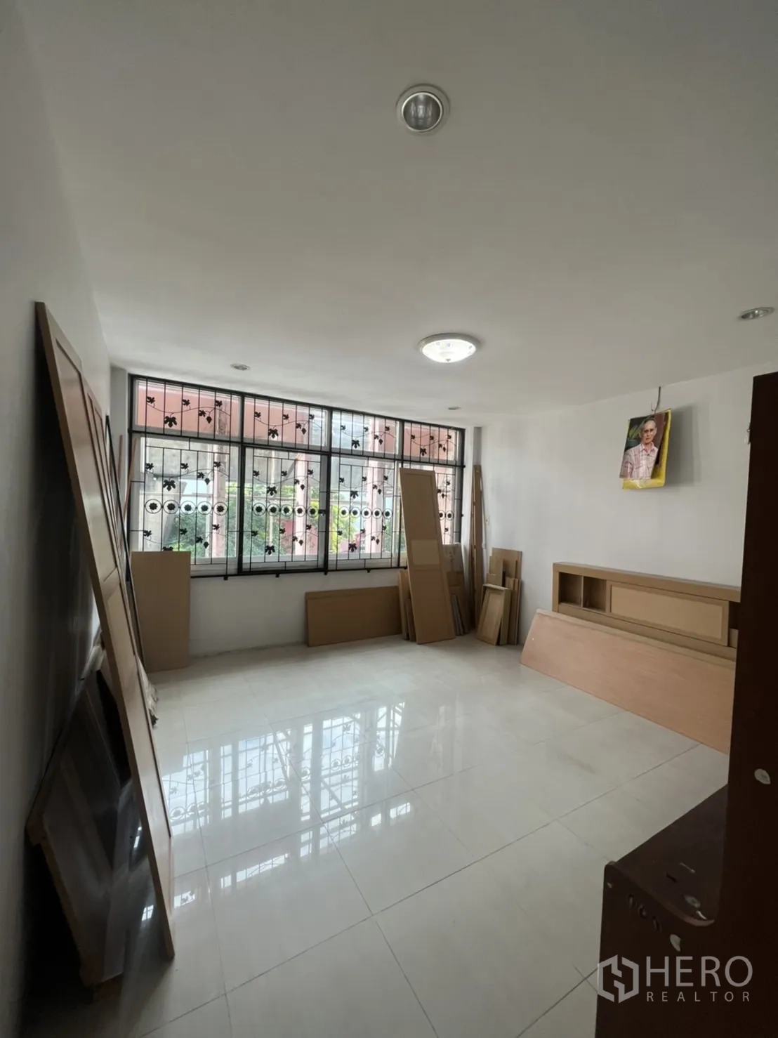 Shophouse for rent in Khlong Toei, Bangkok - Bright upper-floor room with large grilled windows and glossy white tiled flooring, ready for fit-out.