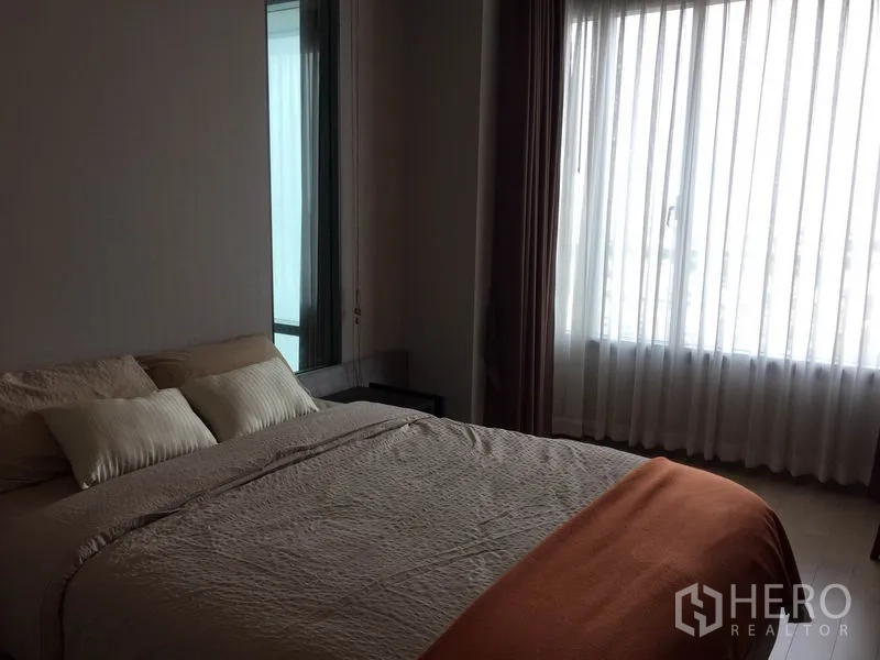 公寓 出租在Ratchathewi, Bangkok - 主卧大窗与纱帘引入城市光线，氛围静谧。