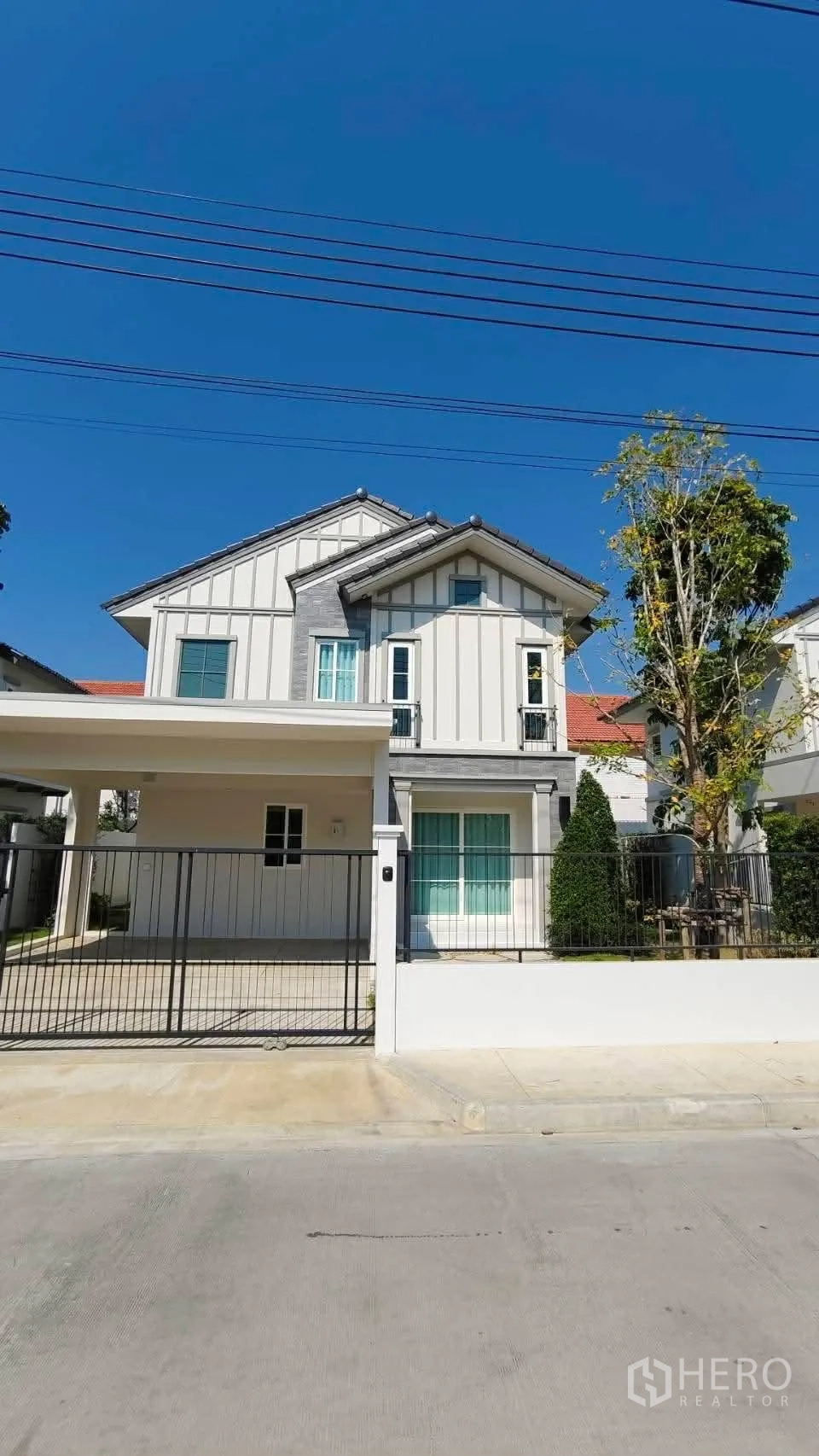 บ้าน for rent in Bang Phli, Samut Prakan - ด้านหน้าบ้านเดี่ยวสองชั้นพร้อมรั้วหน้าบ้าน โรงจอดรถ และสวนหย่อม