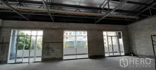 零售空间 出租在Khlong Toei, Bangkok - 店铺内部设落地玻璃推门，连接阳台，可见城市景观。