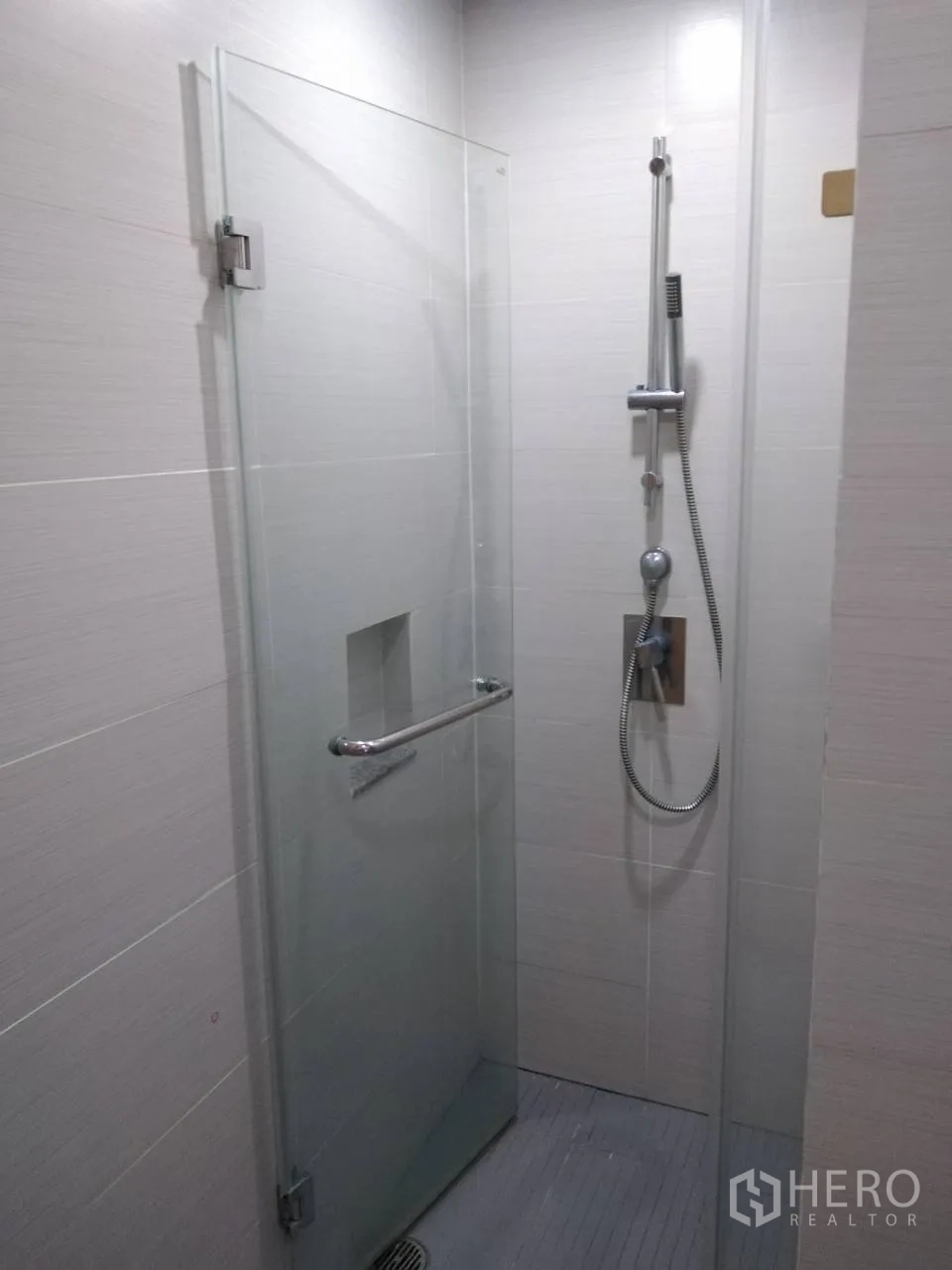 Condominium for rent in Khlong Toei, Bangkok - Glass-enclosed walk-in shower with handheld showerhead and tiled walls.