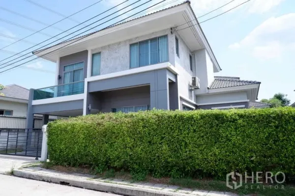 独立式住宅 出售在Lat Krabang, Bangkok - 现代两层外立面，带阳台、绿篱与电动大门车道