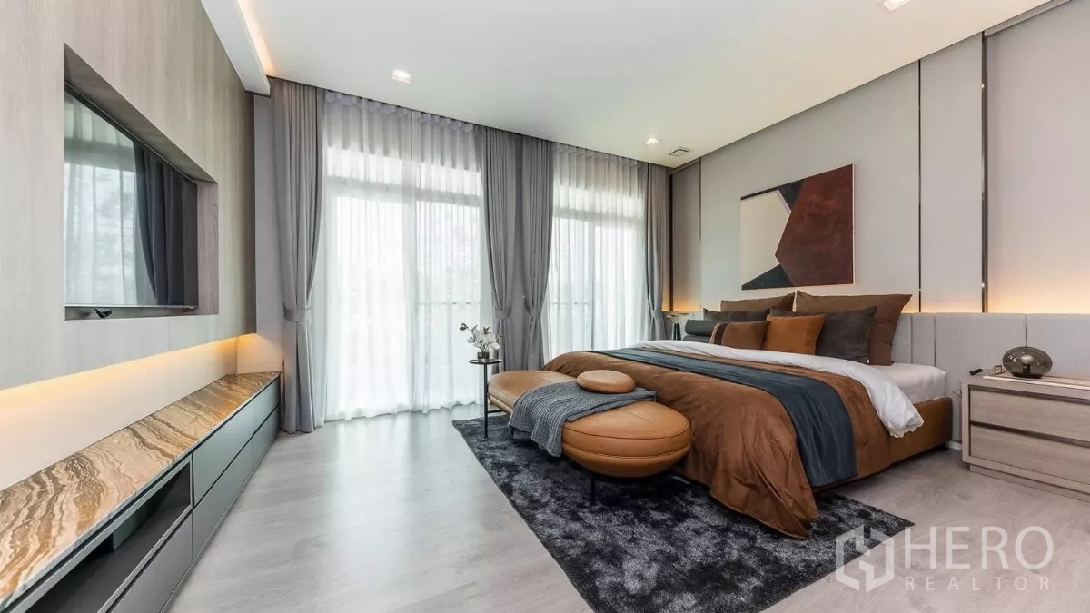 Detached House for rent in Prawet, Bangkok - Spacious master bedroom with king bed, balcony windows and ottoman bench.