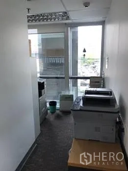 Office Space for rent in Khlong Toei, Bangkok - Copy and print area beside a tall window with city views.