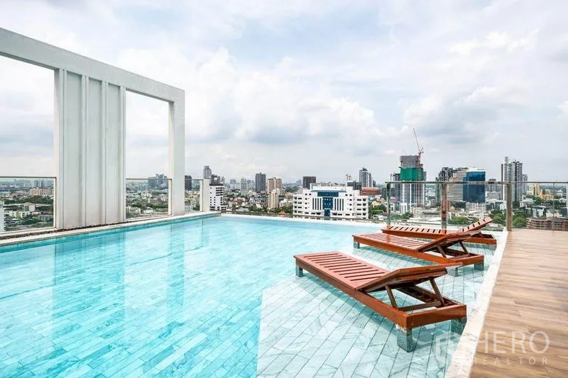 Condominium for rent or sale in Watthana, Bangkok - Rooftop infinity pool with sun loungers and panoramic views over Bangkok.