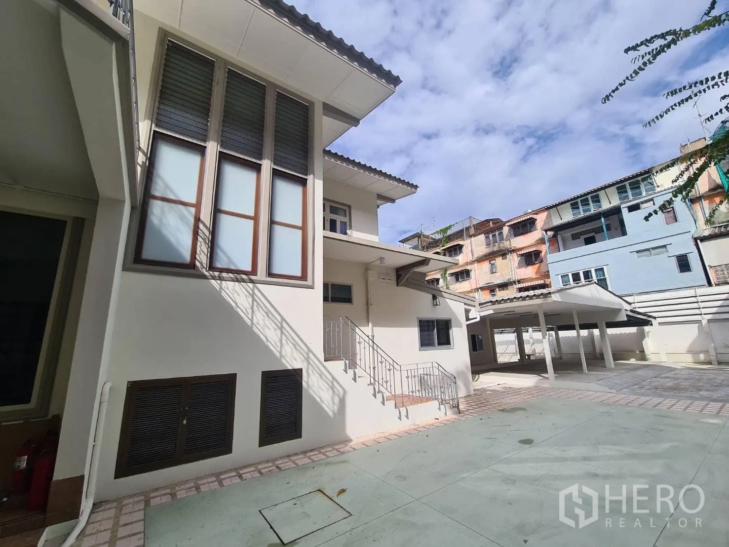 Detached House for rent in Khlong Toei, Bangkok - Side exterior showing tall windows and multiple covered parking bays.