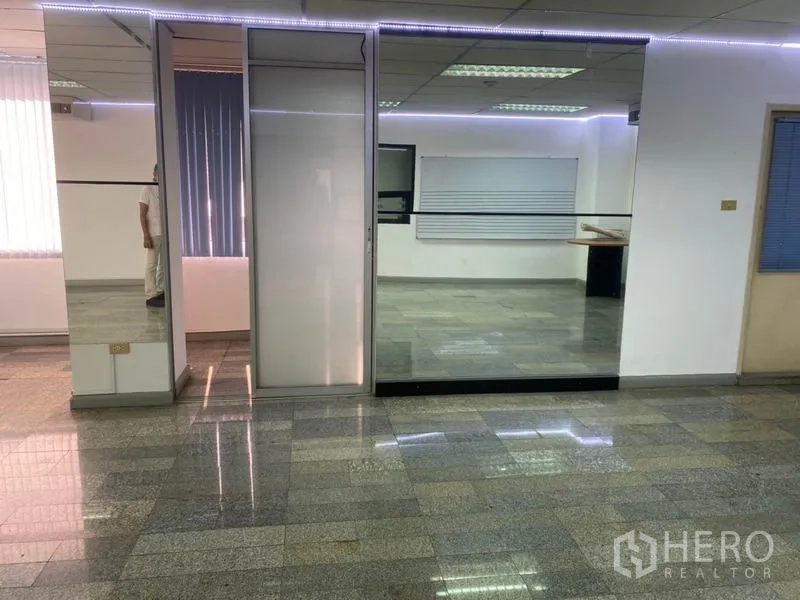 Office Space for rent in Khlong Toei, Bangkok - Office entrance area featuring a floor-to-ceiling glass partition, mirror paneling and subtle LED strip lighting.