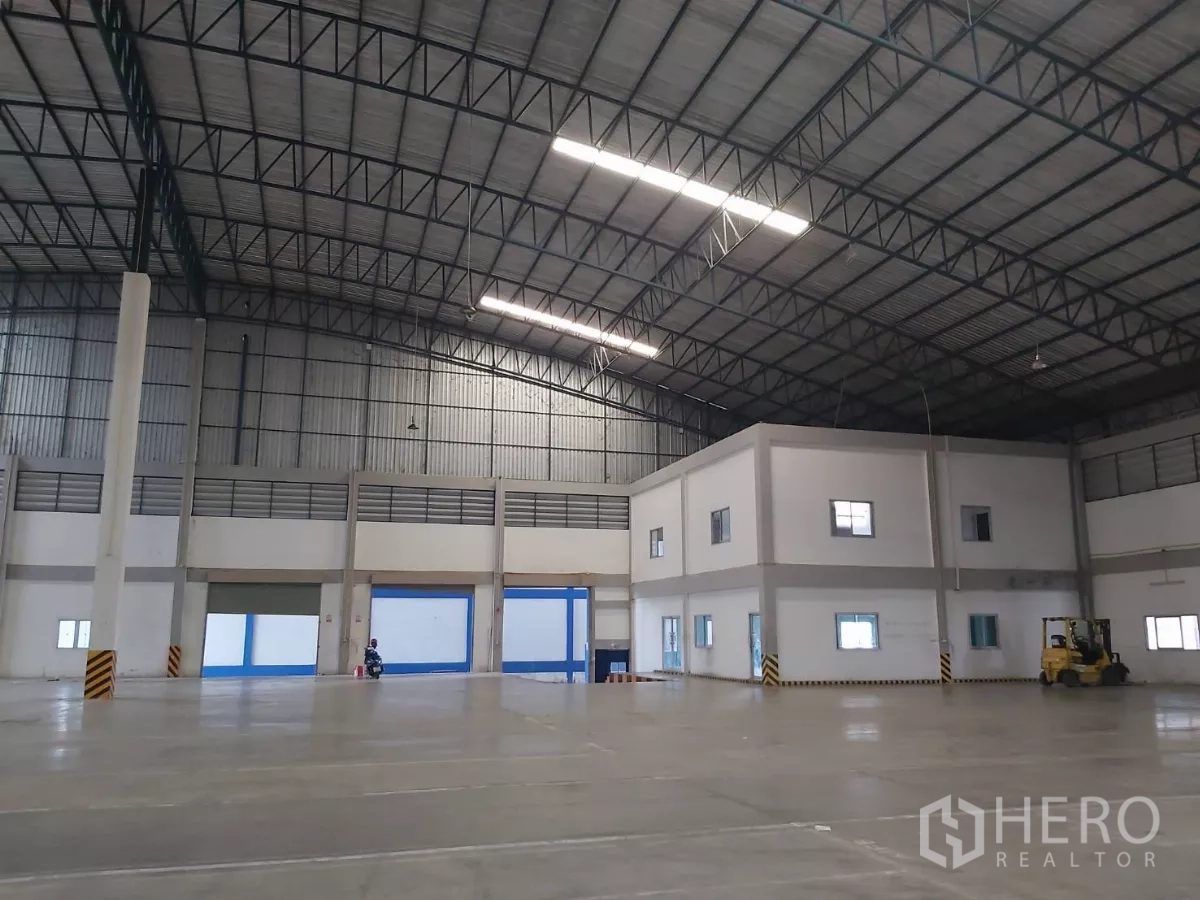 Warehouse for rent in Bang Bo, Samut Prakan - Vast warehouse hall with internal two-story office block and a forklift.